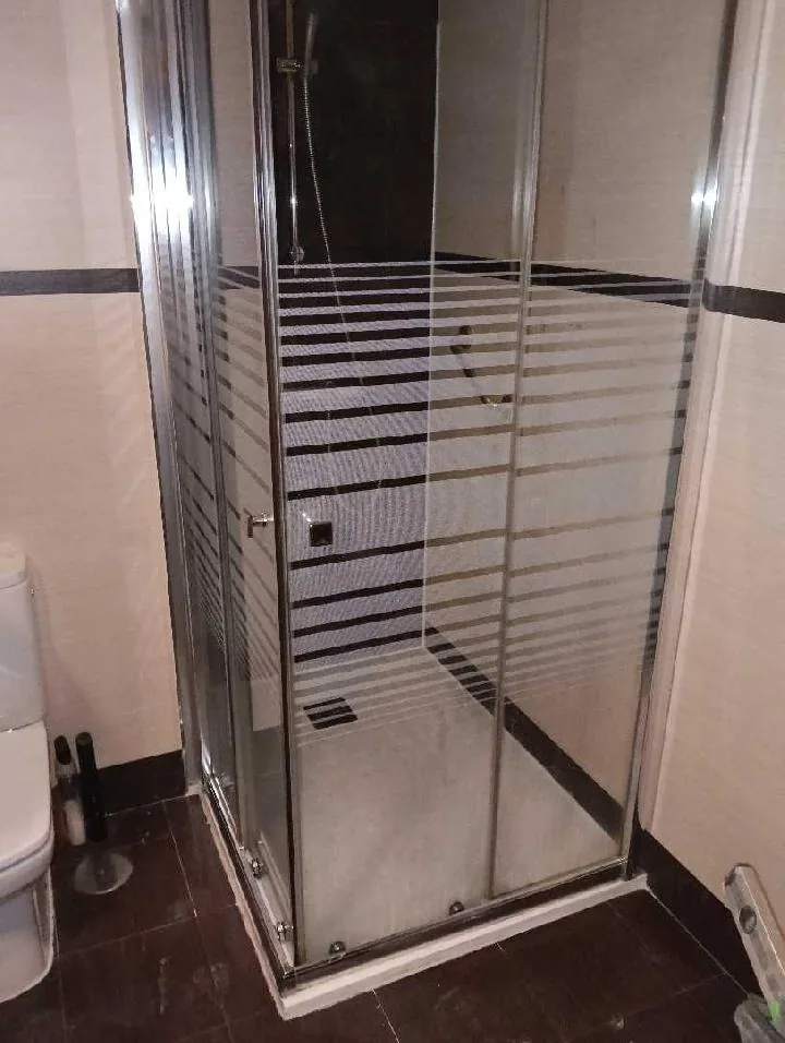 Ducha terminada con mampara de cristal instalada